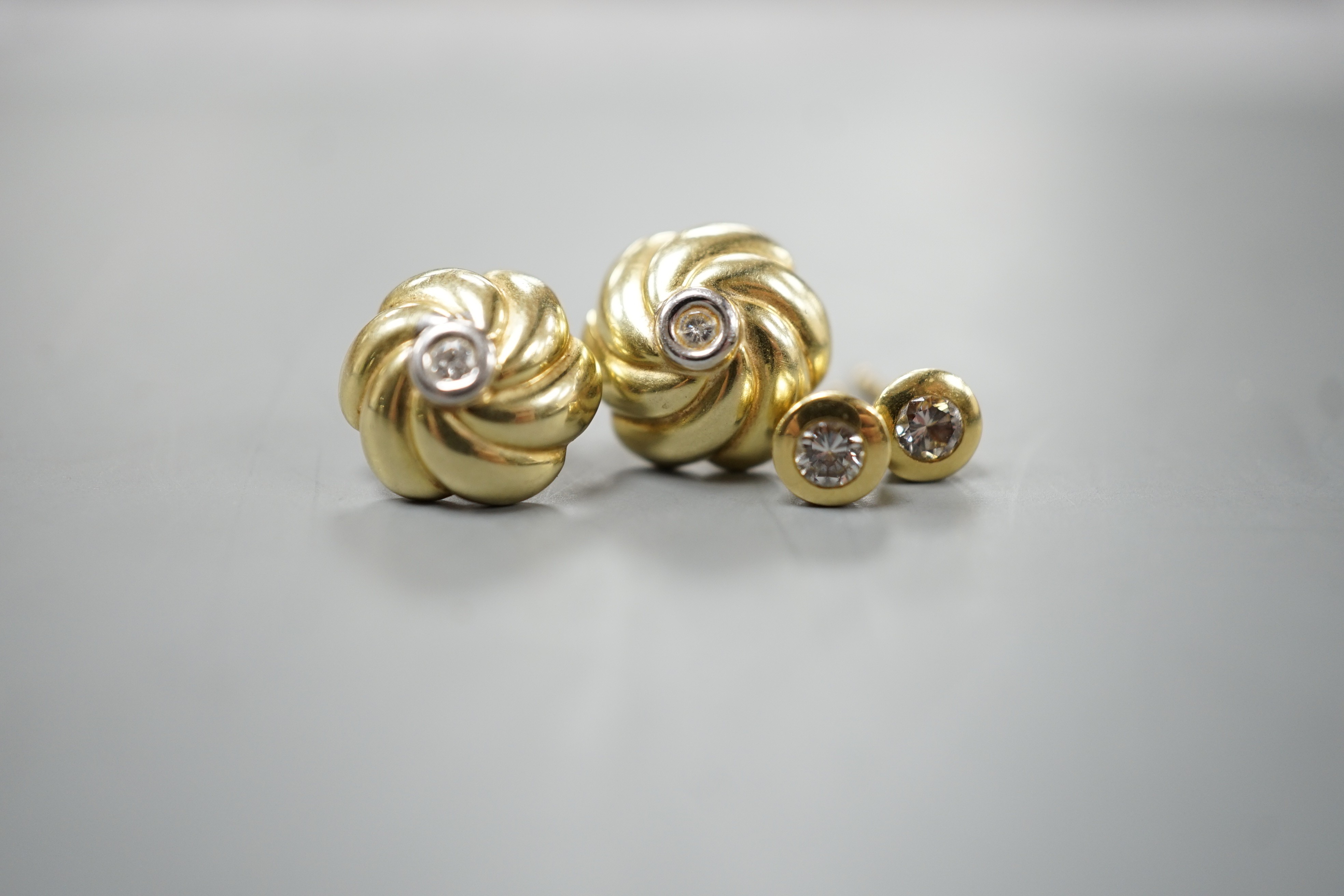 Two pairs of yellow metal and small solitaire diamond set ear studs, gross weight 5.2 grams.